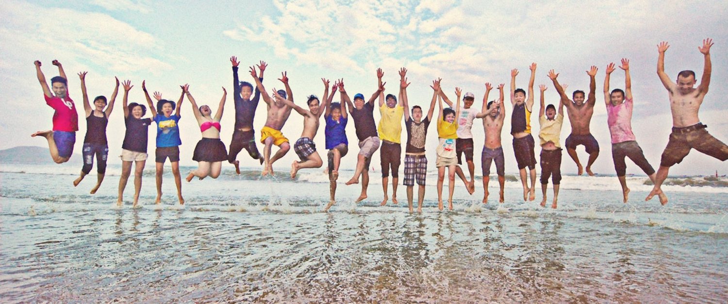 The team jumping in the surf